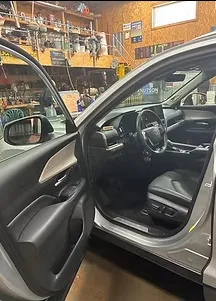 Detailed SUV interior, open door showing clean seats and door panel